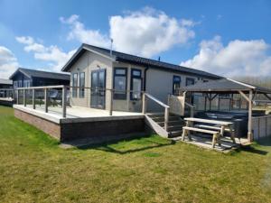 a house with a porch and a picnic table at Remarkable 2-Bed Luxury Lodge in Routh with hottub in Routh