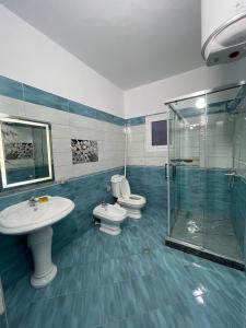 łazienka z 2 toaletami, umywalką i prysznicem w obiekcie Harmony Villa Berat w mieście Berat