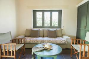 a living room with a couch and a table at Oleander Country House in Patmos