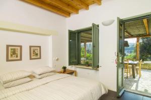 a bedroom with a bed and a large window at Oleander Country House in Patmos