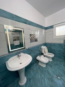 a bathroom with two toilets and a sink and a mirror at Harmony Villa Berat in Berat +40 photos