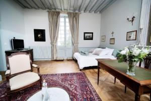 a living room with a couch and a table at Le Petit Serrant - maison d'hôtes d'exception in Bouchemaine