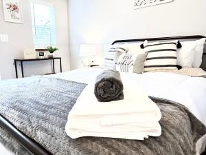um quarto com uma cama com lençóis brancos e almofadas em Time Travel Inn em Birnamwood