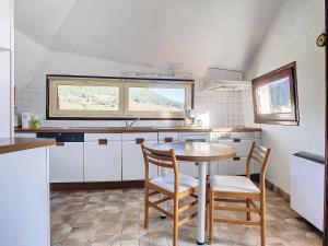 a kitchen with a table and two chairs in it at Authenticité, jardin, terrasse et vue in Chanac