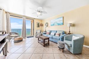 a living room with a blue couch and chairs at Romar Place Unit 904 in Orange Beach