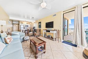 a living room with a blue couch and a tv at Romar Place Unit 904 in Orange Beach