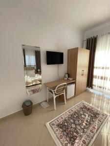 a living room with a table and a desk with a television at Harmony Villa Berat in Berat