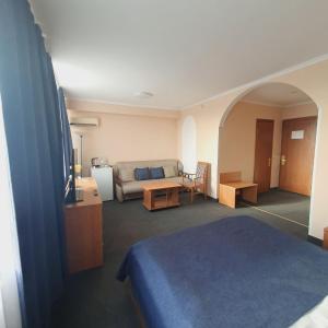 a hotel room with a bed and a couch at Aktobe Hotel in Aktobe