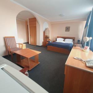 a hotel room with a bed and a desk at Aktobe Hotel in Aktobe