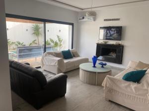 uma sala de estar com dois sofás e uma lareira em Dar Selima Hammamet em Hammamet