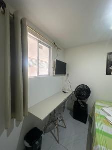a white desk in a bedroom with a window at Aero-Quarto aconchegante 2 in Bayeux