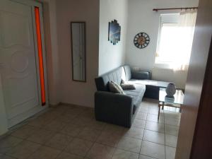 ein Wohnzimmer mit einem Sofa und einem Tisch in der Unterkunft Georgios home in Iraklio