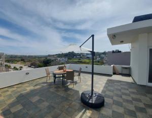 a patio with a table and chairs on a roof at Georgios home in Heraklio