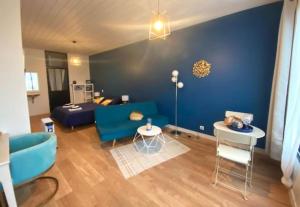 uma sala de estar com um sofá azul e uma mesa em Chambre Californie - Old School em Port-Joinville