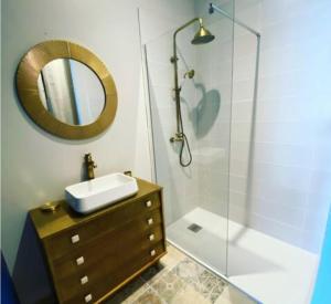 a bathroom with a sink and a shower with a mirror at Chambre Californie - Old School in Port-Joinville +9 photos