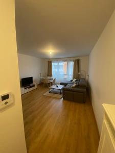 a living room with a couch and a table at Appartement JO, proche Paris in Guyancourt