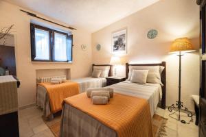 Habitación de hotel con 2 camas con sábanas de color naranja en Trullo Gioia, en Vaglio di Basilicata