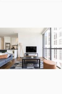 a living room with a couch and a table at Bright City Views Melbourne Central Penthouse on Collins in Melbourne