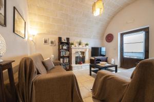 ein Wohnzimmer mit einem Sofa und einem Kamin in der Unterkunft Trullo Gioia in Alberobello