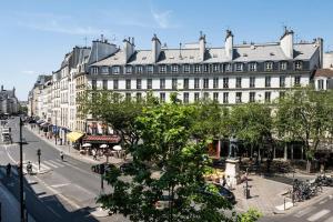 een groot wit gebouw aan een stadsstraat bij Pavillon Eden « Le cocon » in Parijs