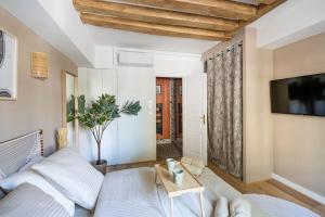 een slaapkamer met een wit bed en een tv bij Pavillon Eden « Le cocon » in Parijs