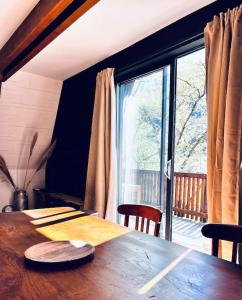 drewniany stół w pokoju z dużym oknem w obiekcie Le ChAlet N5 w mieście Cierp