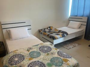 杜拜的住宿－Purity Inn JVC，小房间设有两张床和椅子