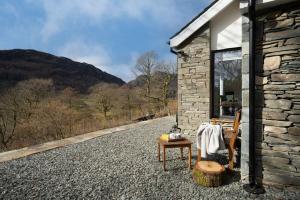 a stone house with a table and chairs on a gravel road at Serene Retreat in Chapel Stile by LetMeStay in Ambleside