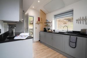 a kitchen with white cabinets and black counter tops at Serene Retreat in Chapel Stile by LetMeStay in Ambleside