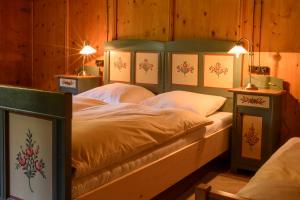 a bedroom with a bed in a room with wooden walls at Sandrellhaus in Tschagguns