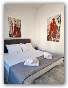 Welcome Home Syros Port Apartment في إرموبولّي: سريرين في غرفة مع ملصقات على الحائط