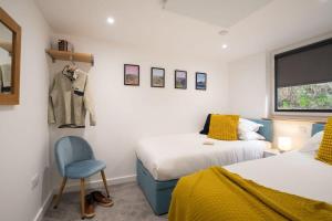 a bedroom with two beds and a chair and a window at Serene Retreat in Chapel Stile by LetMeStay in Ambleside