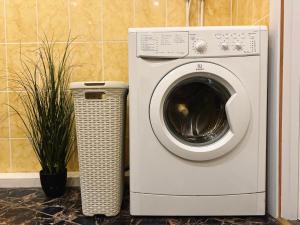 a washing machine sitting next to a trash can at Kyiv Panna Apartment in Kyiv
