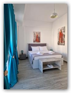 a bedroom with a bed and a blue curtain at Welcome Home Syros Port Apartment in Ermoupoli