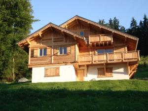 drewniany dom z balkonem na polu w obiekcie Le Caribou w mieście Saint-Gervais-les-Bains