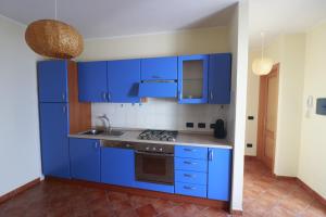 una cucina blu con lavello e armadi blu di Salt Whisper - Salt Whisper - Bilocale con terrazzi e piscina a La Caletta