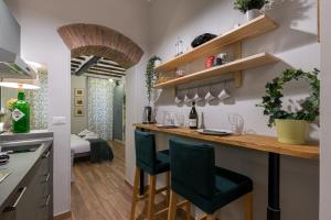 uma cozinha com um bar com duas cadeiras verdes em Rome as you feel - Piazza dei Satiri apartments em Roma