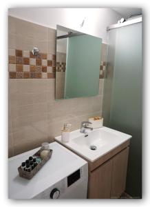y baño con lavabo y espejo. en Welcome Home Syros Port Apartment, en Ermoupoli
