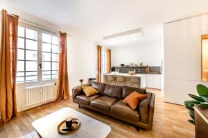 ein Wohnzimmer mit einem Sofa und einer Küche in der Unterkunft Elegance and high standing in the city center in Lyon