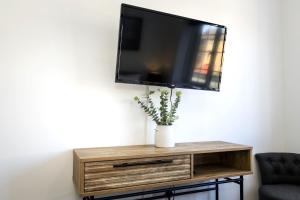 Elle comprend une télévision à écran plat sur une table en bois. dans l'établissement Pier View - stylish flat with sea views, à Eastbourne