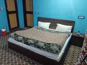 - un grand lit dans une chambre aux murs bleus dans l'établissement Apple Garden View and Restaurant, à Pahalgām