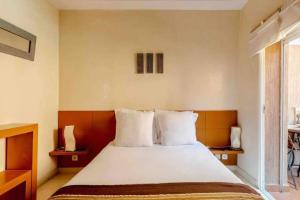 um quarto com uma cama grande e 2 almofadas em Joli appartement centre Gueliz em Marrakech