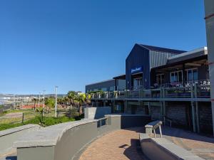 un edificio con un banco frente a un parque de patinaje en 22 on Port Natal Hartenbos, en Hartenbos