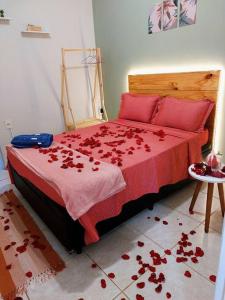 - une chambre avec un lit orné de fleurs rouges au sol dans l'établissement Refúgio nas Flores - confirme após o pedido de reserva, à Holambra