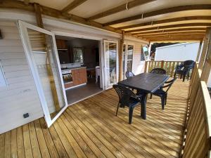 una terrazza in legno con tavolo e sedie. di Mobil home Neuf Haut standing a Canet-en-Roussillon
