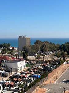 een parkeerplaats gevuld met geparkeerde auto's naast de oceaan bij Apartamento con vistas al mar in Oropesa del Mar