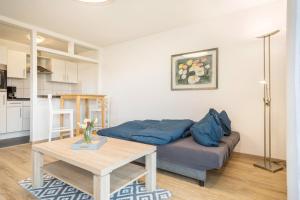 uma sala de estar com um sofá e uma mesa em Am Dorfweiher em Tettnang
