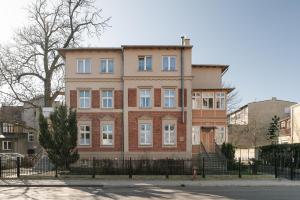 un immeuble d'appartements dans une ville avec une clôture dans l'établissement Sanhaus Apartments - Apartamenty Koral z parkingiem - 200 m od plaży, à Sopot