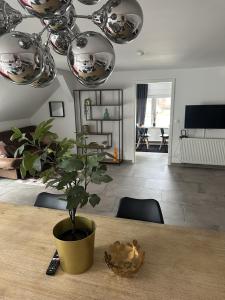 un salon avec une table et une plante en pot dans l'établissement Deluxe Loftapartement Big Size, à Duisbourg