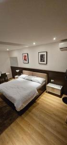 a bedroom with a large bed and two pictures on the wall at FLAT 20 in Abuja